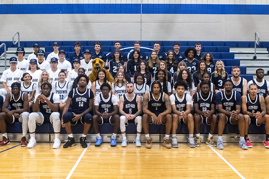 A large group of student-athletes sitting on bleachers.