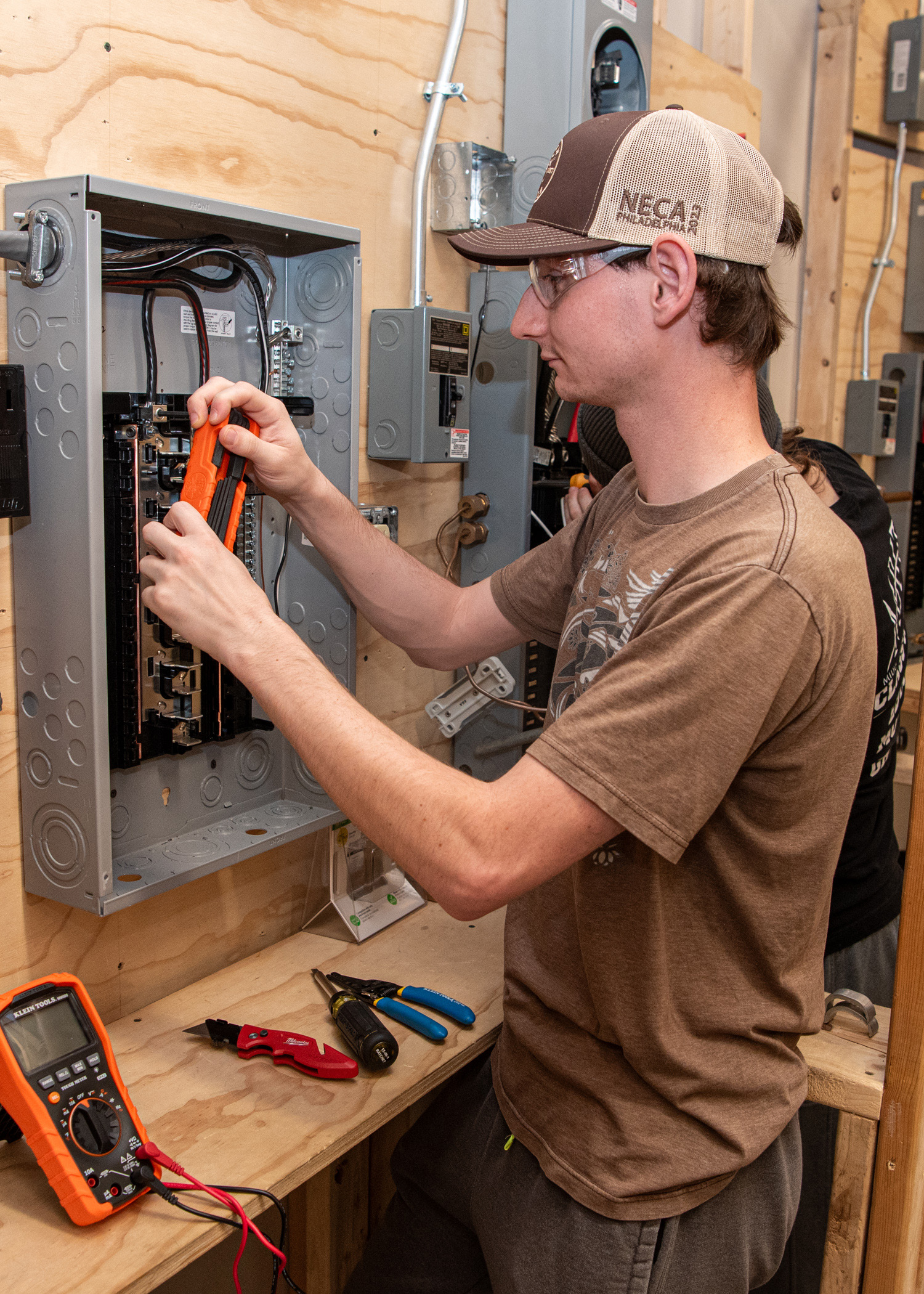 A person working on a load center circut breaker on a wall