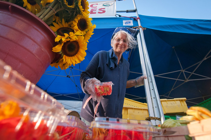 Person setting up a farmer's market stand.