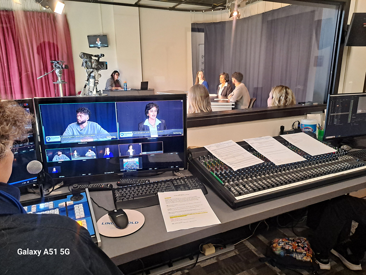 Three people seated at a table in a TV studio