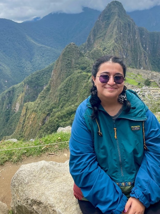 A young woman sitting in front of Machu Picchu