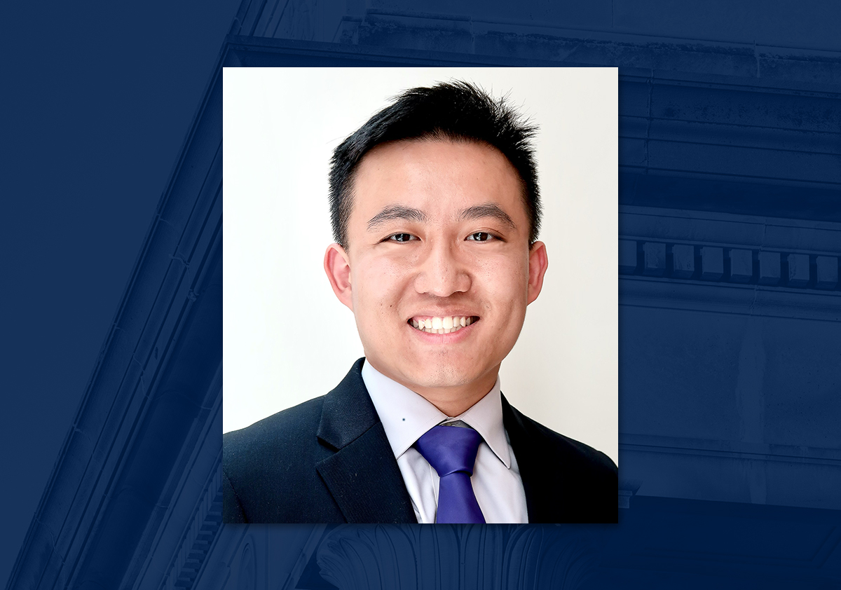 Student dressed in business professional attire smiling for a photo against a white background.