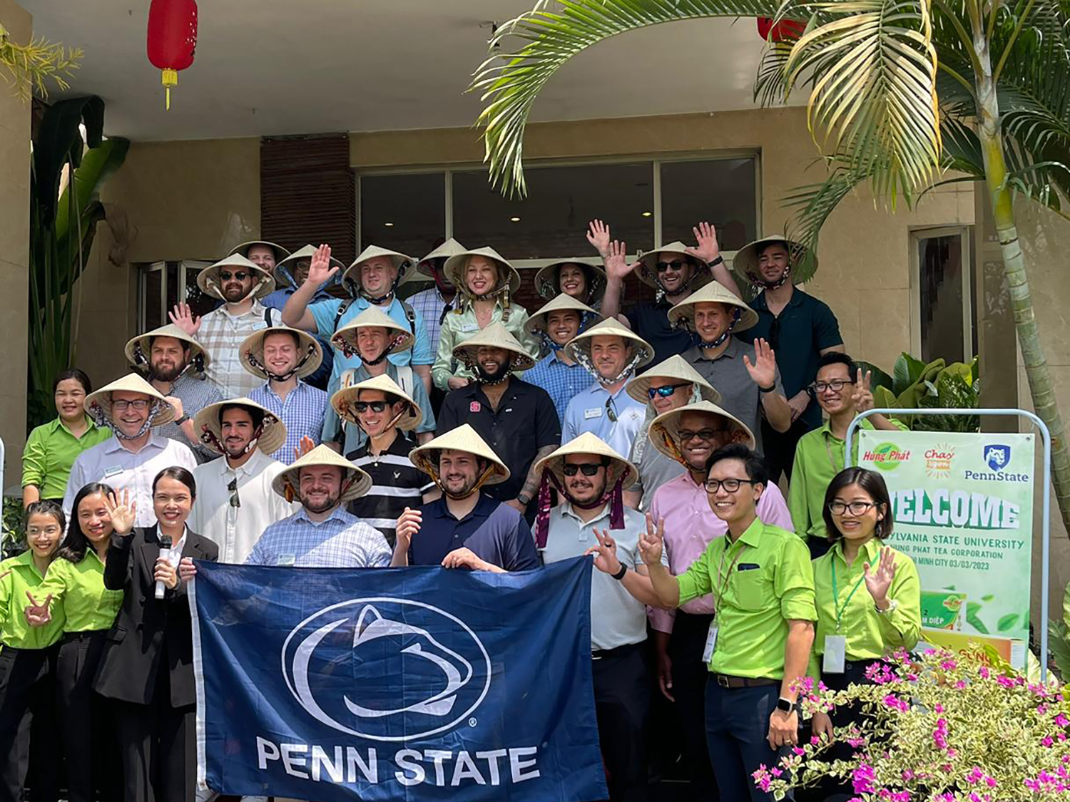 A photo of a group of Penn State Smeal students pose holding a Penn State flag in Vietnam.