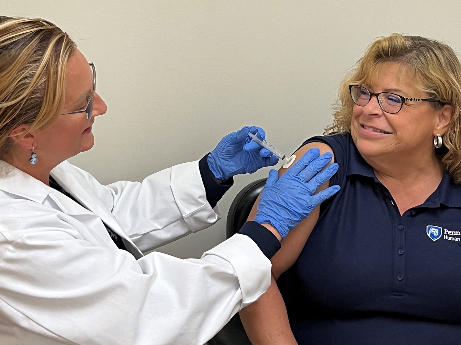 A Penn State employee receiving their flu vaccine from a member of the UHS staff.