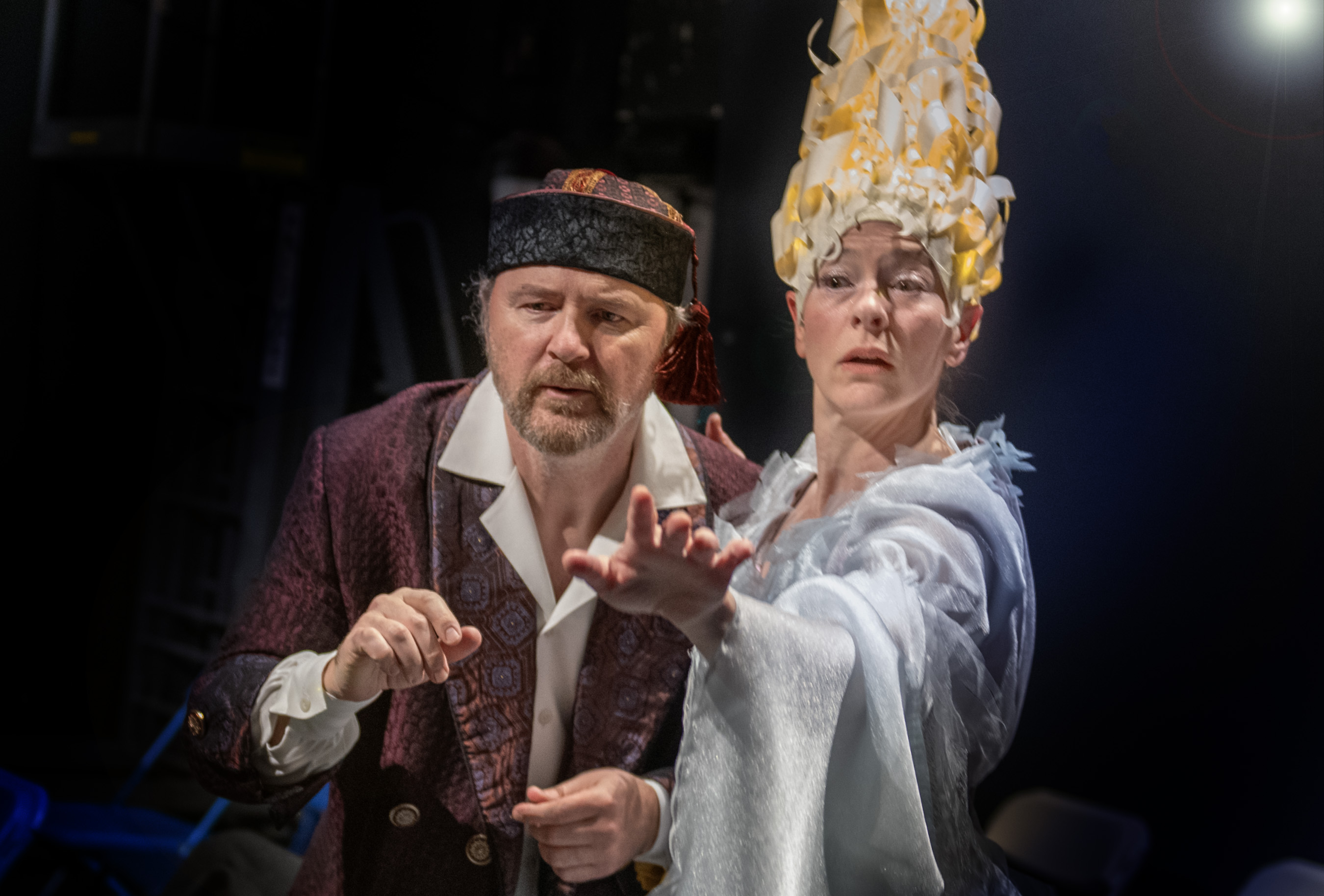 Two people dressed in costumes act in a performance of A Christmas Carol