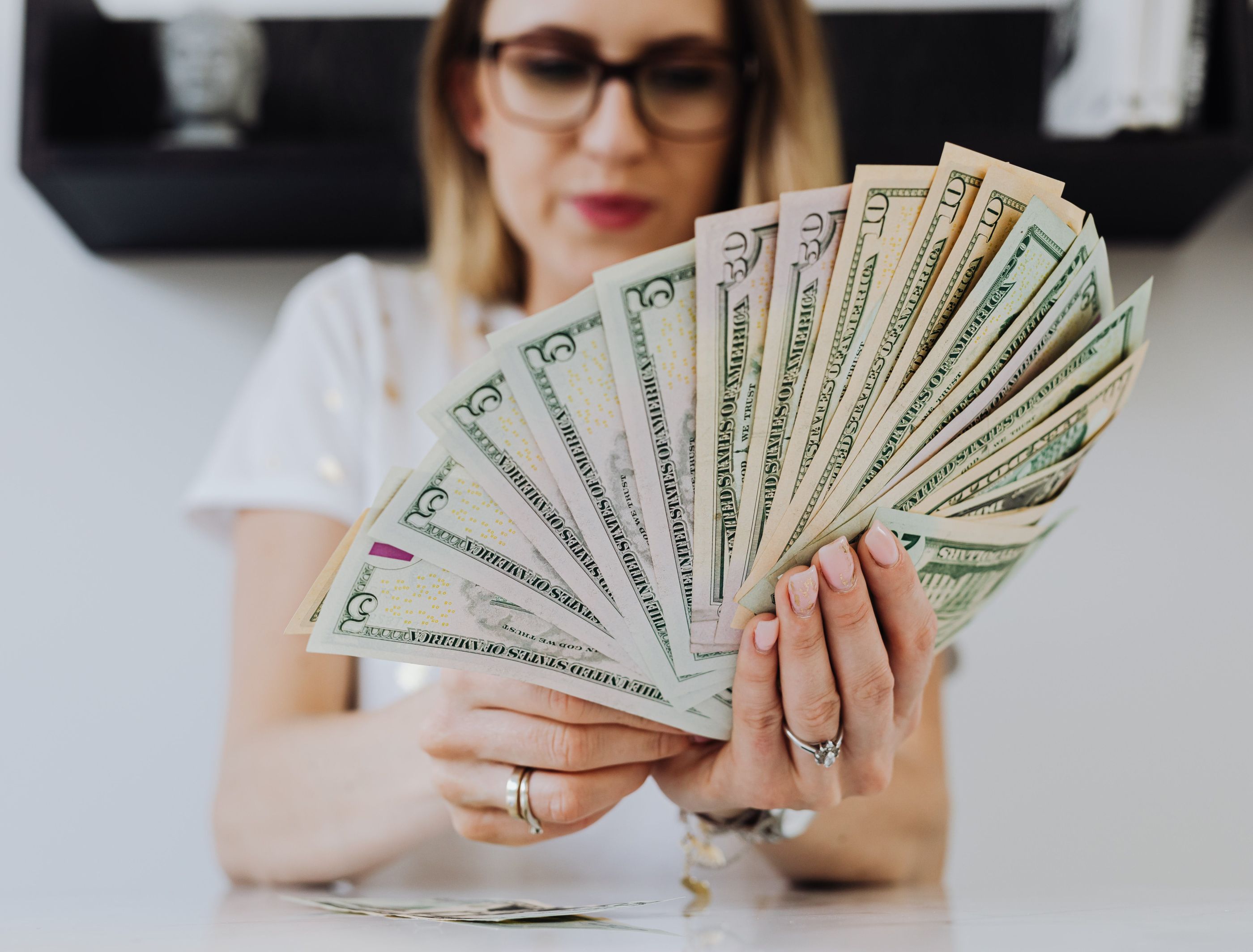 woman holding money to show financial wellness_Karolina Grabowska via Pexels