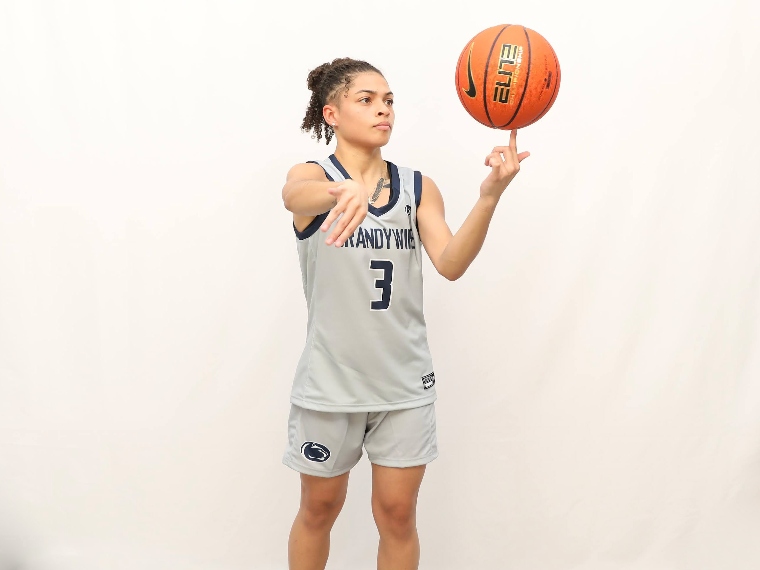 Jenaya Smith wearing Brandywine women's basketball jersey, number 3, spinning a basketball in her hand