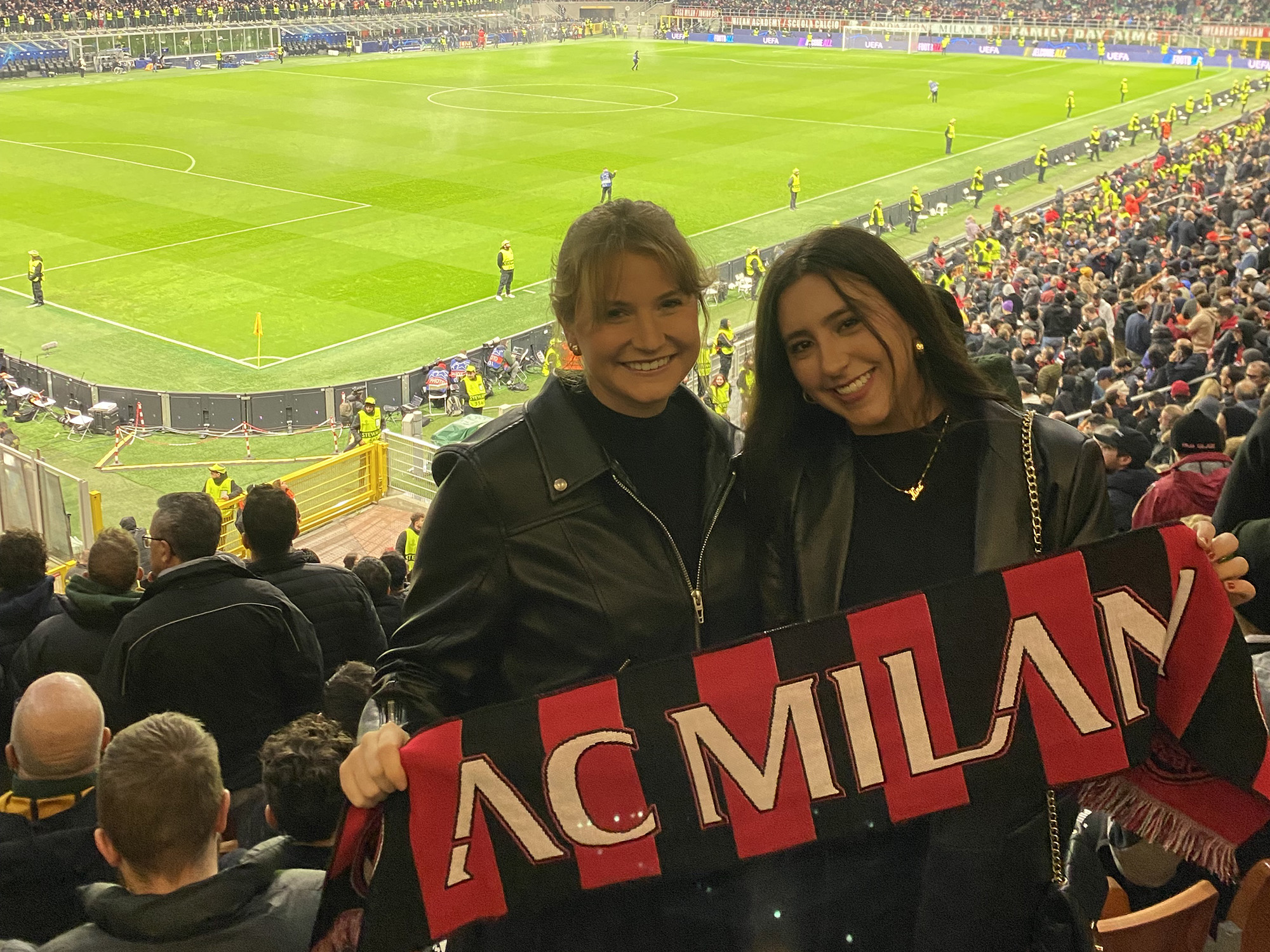 Two people standing in a stadium. 