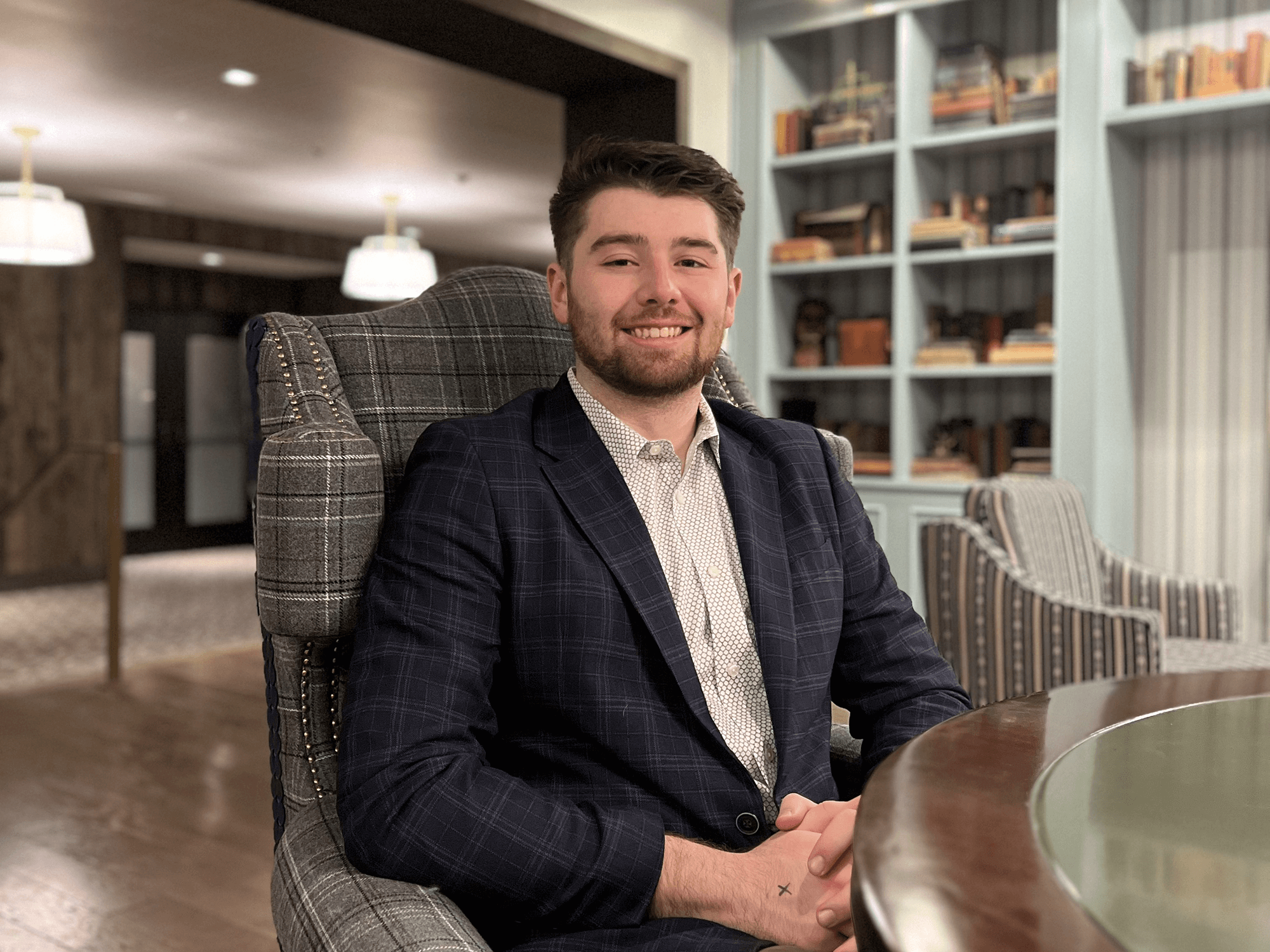 Reese Hays, a third-year Penn State student double majoring in political science and criminology, sits in an armchair at a table. 