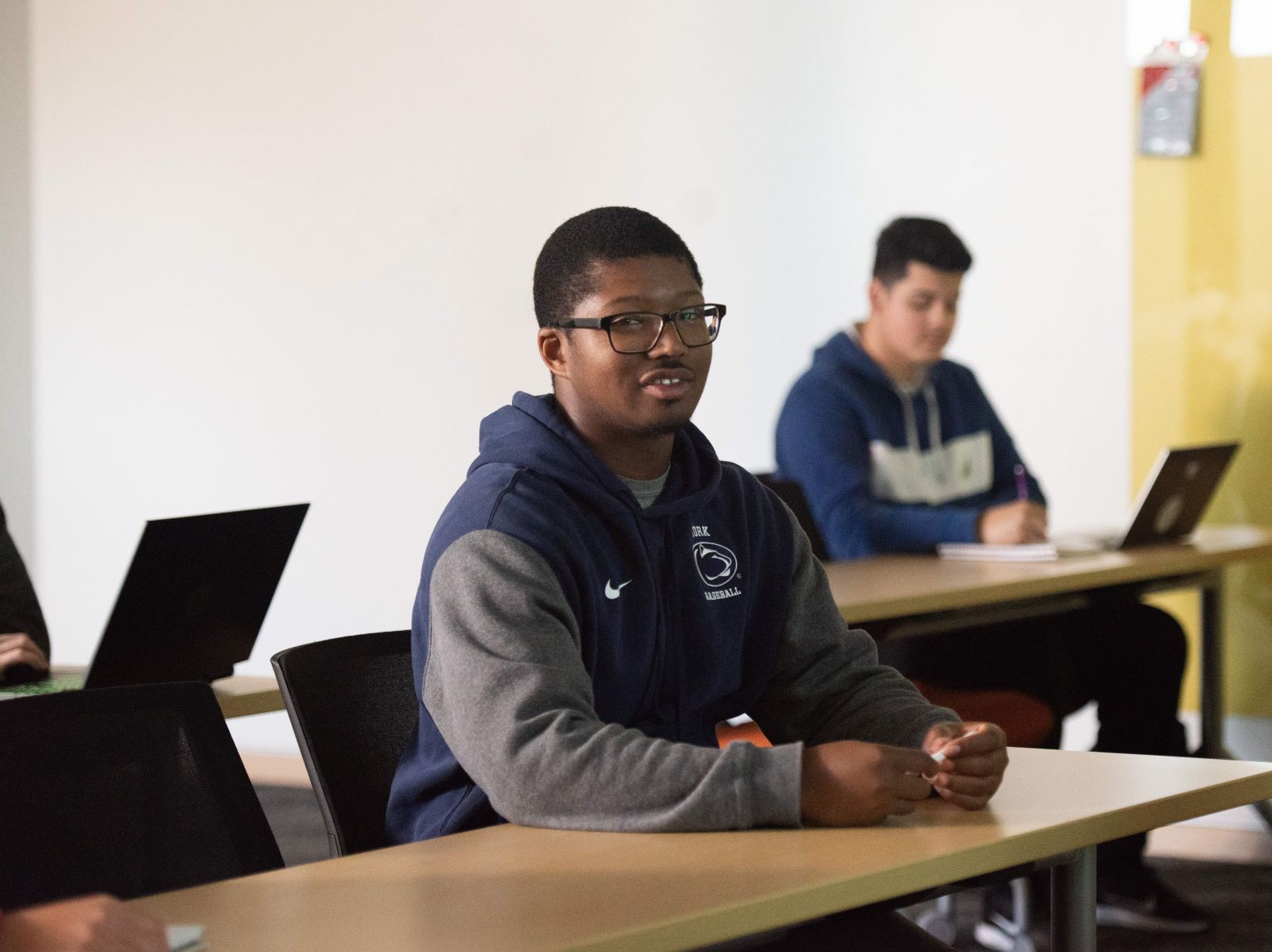 African American student and caucasian student at desks in class