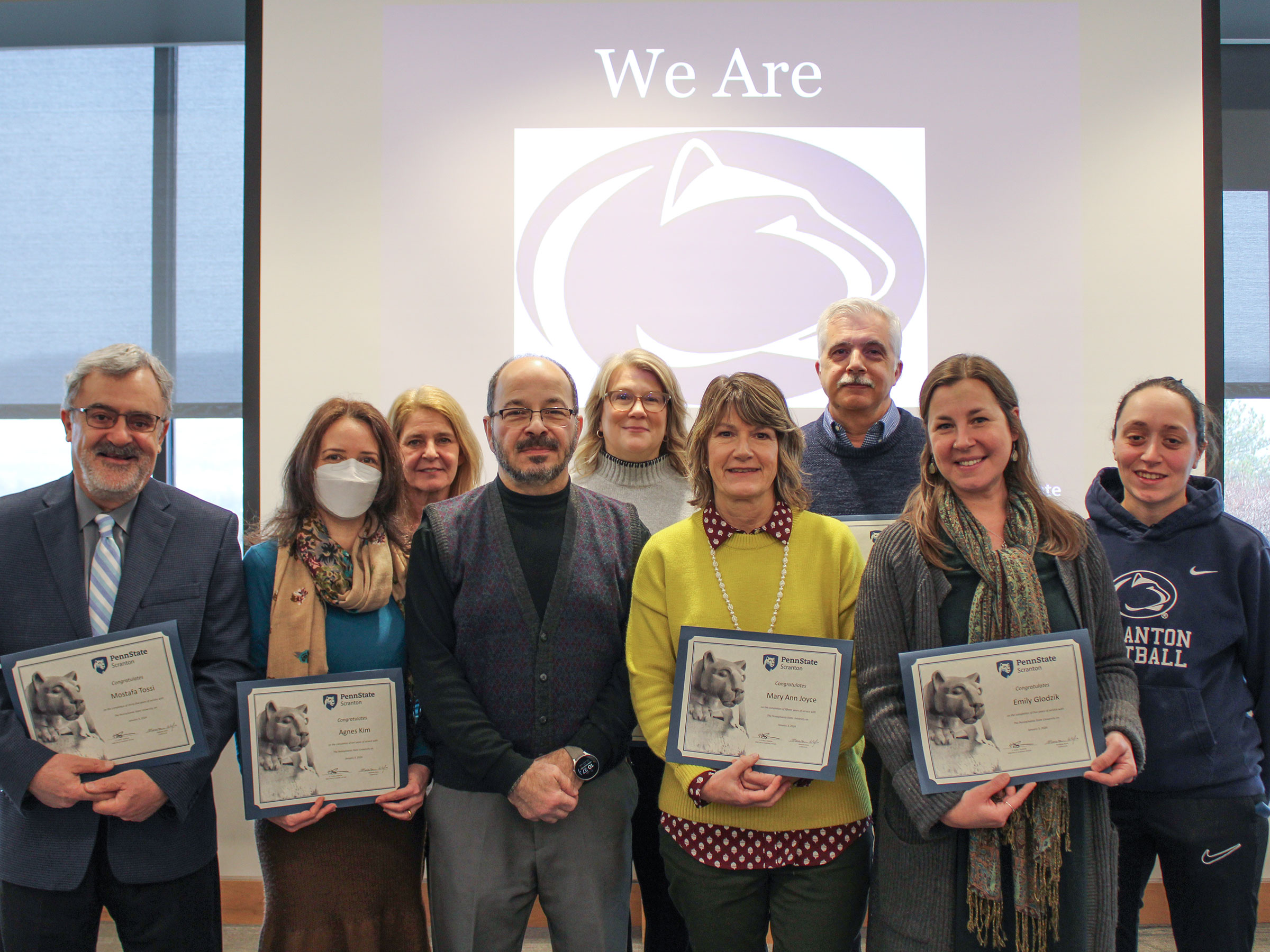 group of service award recipients holding their paper certificates