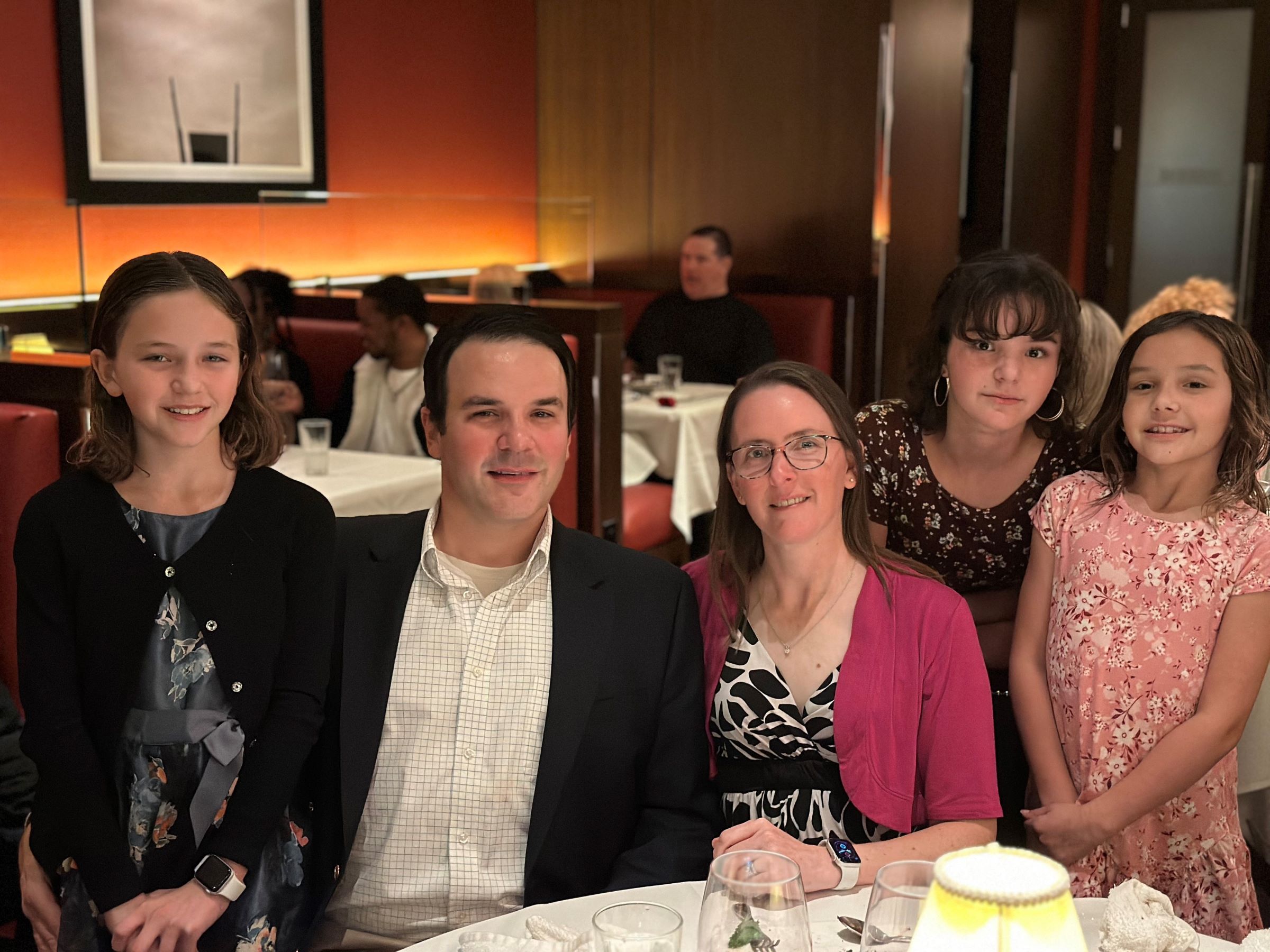 family of five seated at semi-formal dinner table