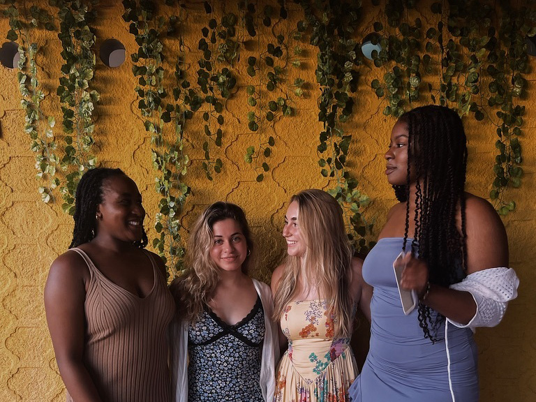 Four students at The Hills in Curaçao at a class farewell dinner during an embedded course trip to Curaçao in November 2023