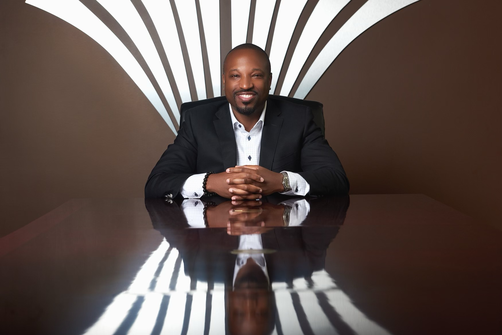 smiling person in business attire seated at desk