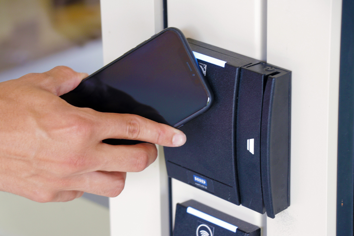 Person using the mobile id+ card on their phone to access a building. 