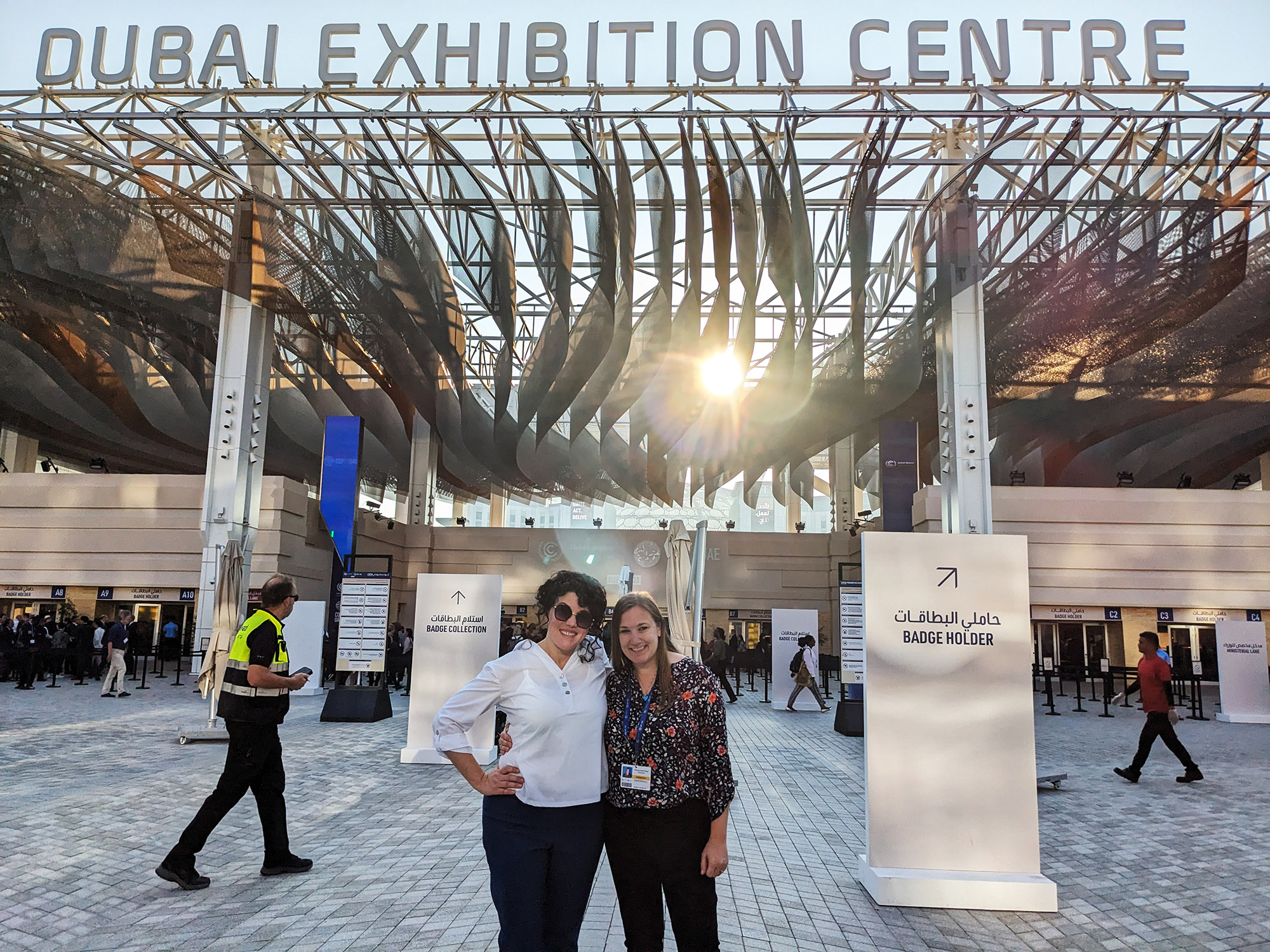 Olivia McMahon and Brandi Robinson post together for a photo in the outdoor lobby of the conference