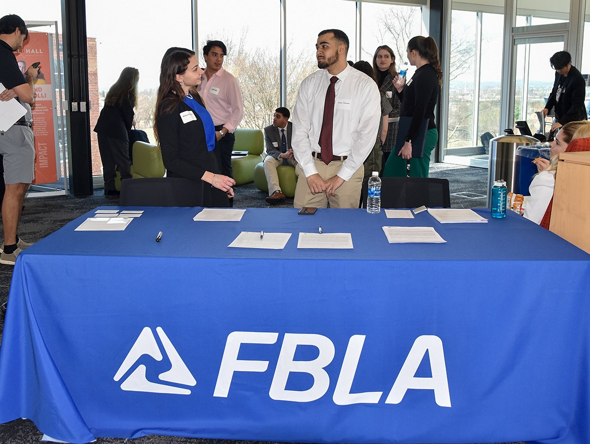 Students dressed in professional clothing networking with each other