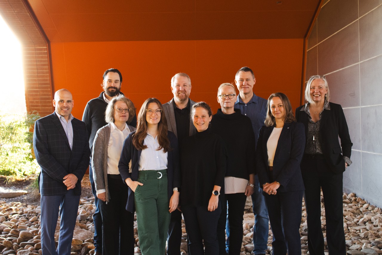 Photo of 10 people standing in front of a building.