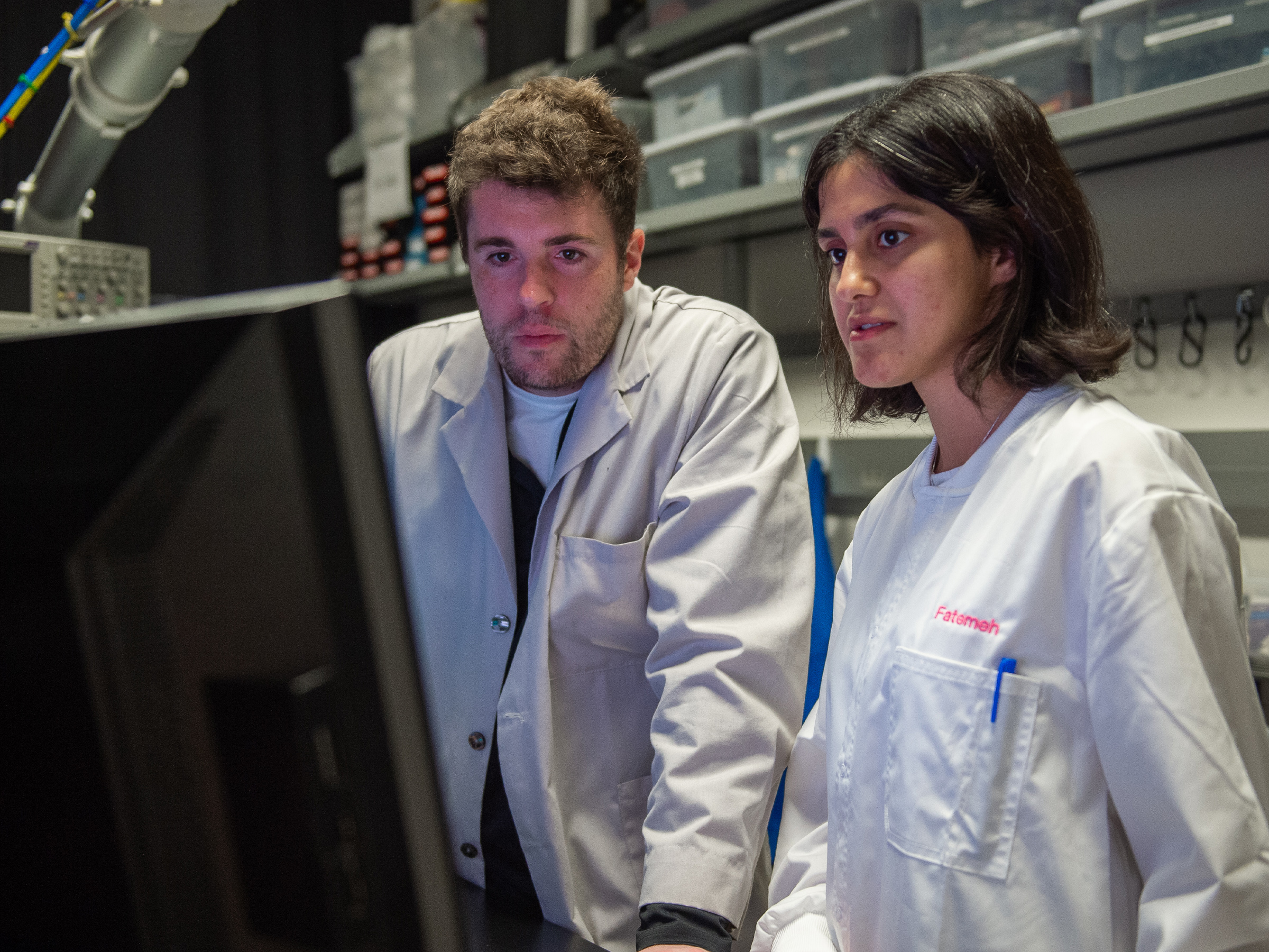 Two people in a lab look a computer monitor