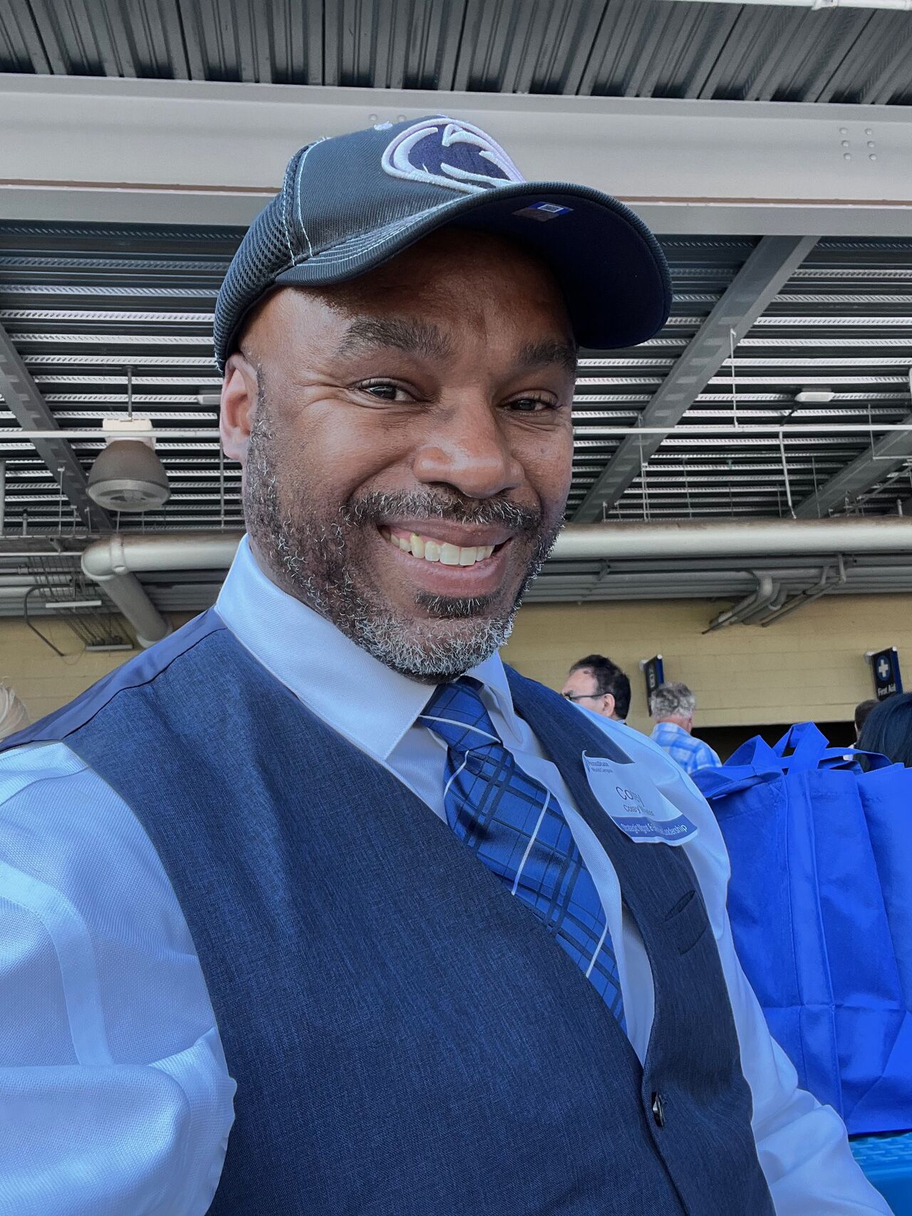 smiling person wearing baseball cap