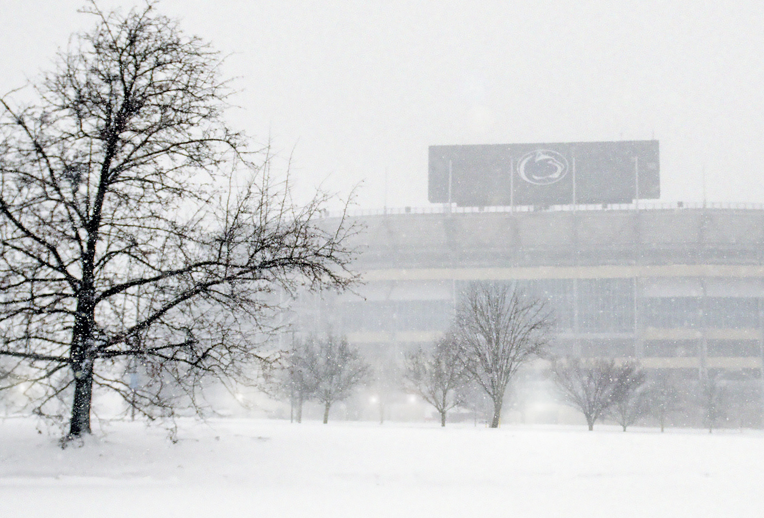 A winter day at University Park, with snow falling and Beaver Stadium in the background