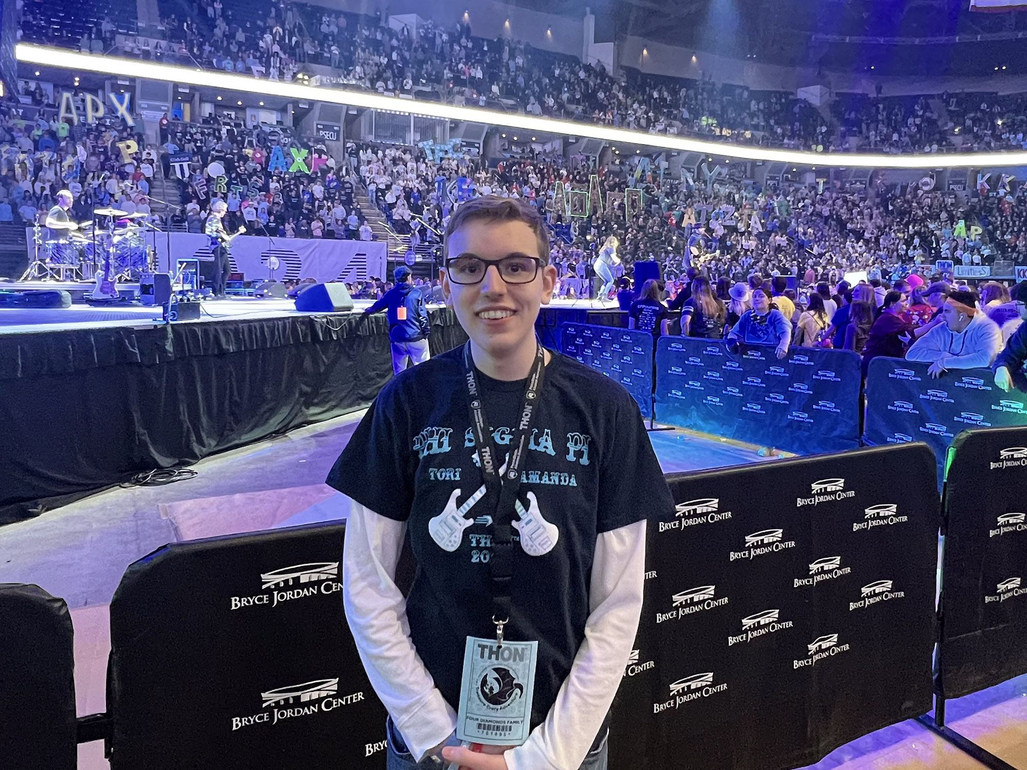 Braden Fleagle stands in front of a stage in an arena