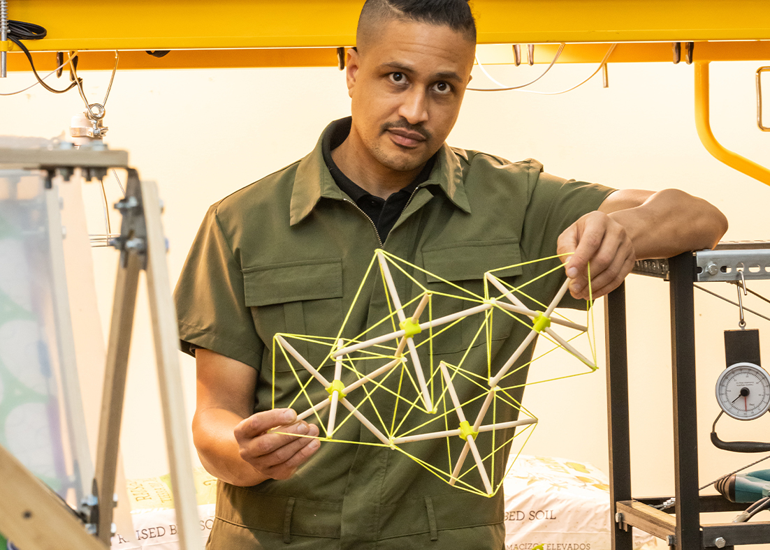 DK Osseo-Asare holding a model of a bamboo structure in his lab.