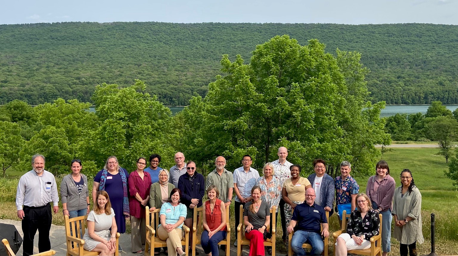 A large group of people posing for a picture in front of trees outside