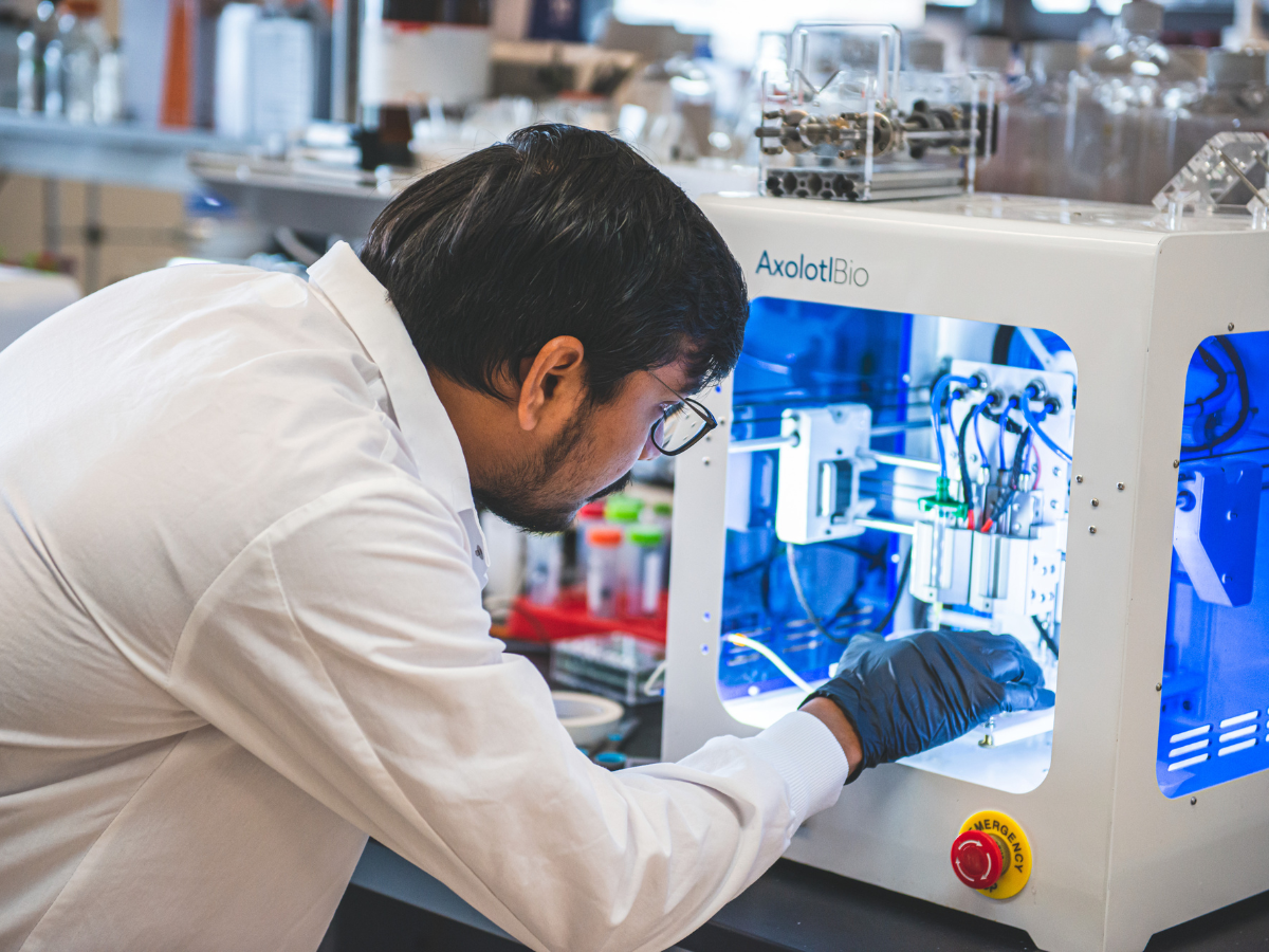 A researcher using additive manufacturing equipment