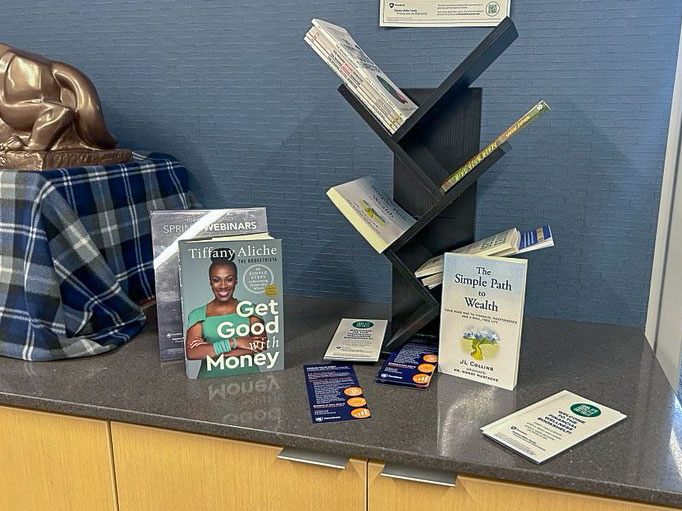 Books and brochures on financial wellness on a table in the admissions office