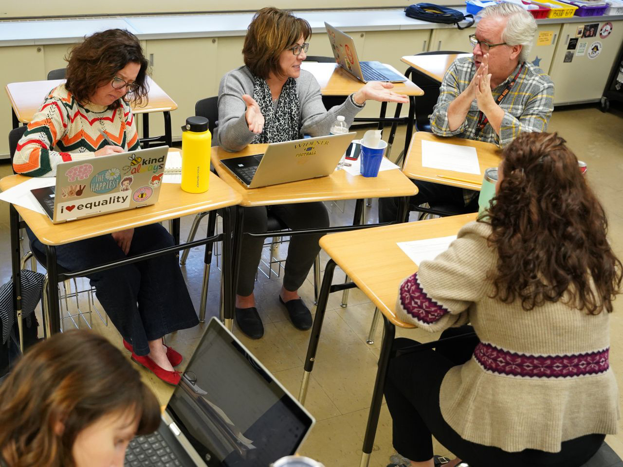 Group of teachers at desks with laptops