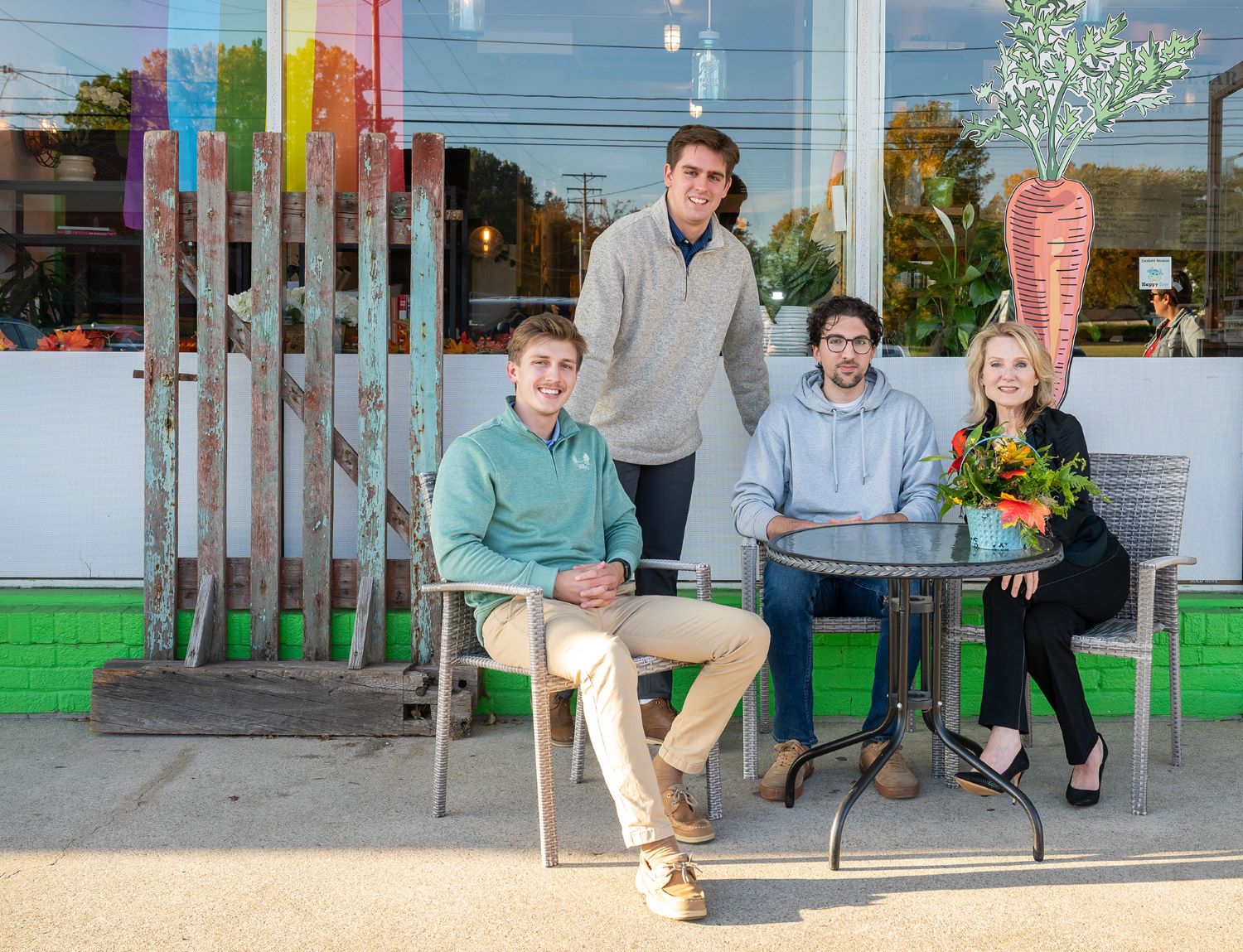 Three Penn State Behrend students pose with the owner of a local cafe.