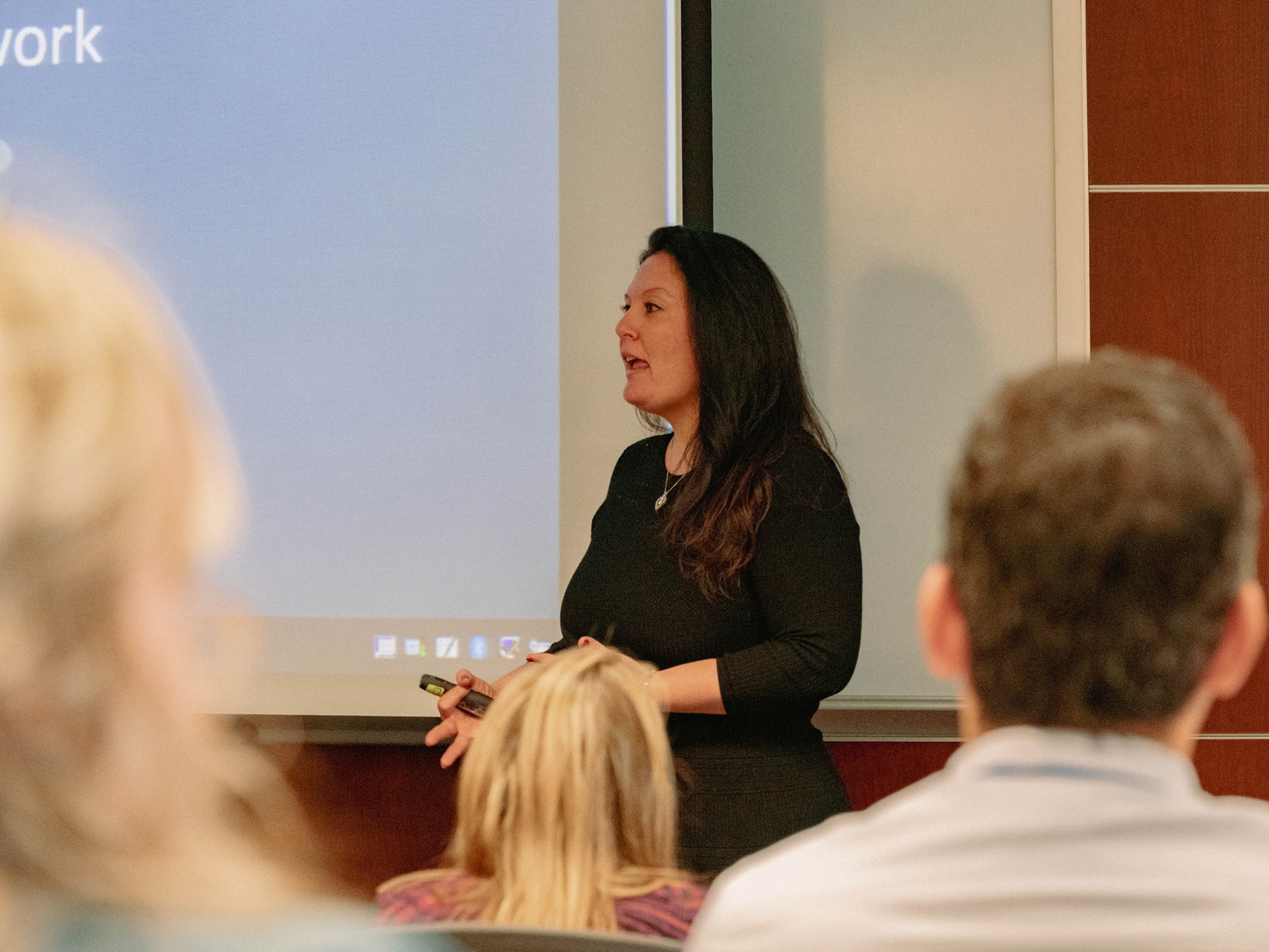 Business woman presenting in front of audience.