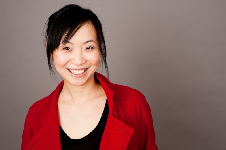 Head shot Asian woman with dark hair wearing a red sweater and smiling 