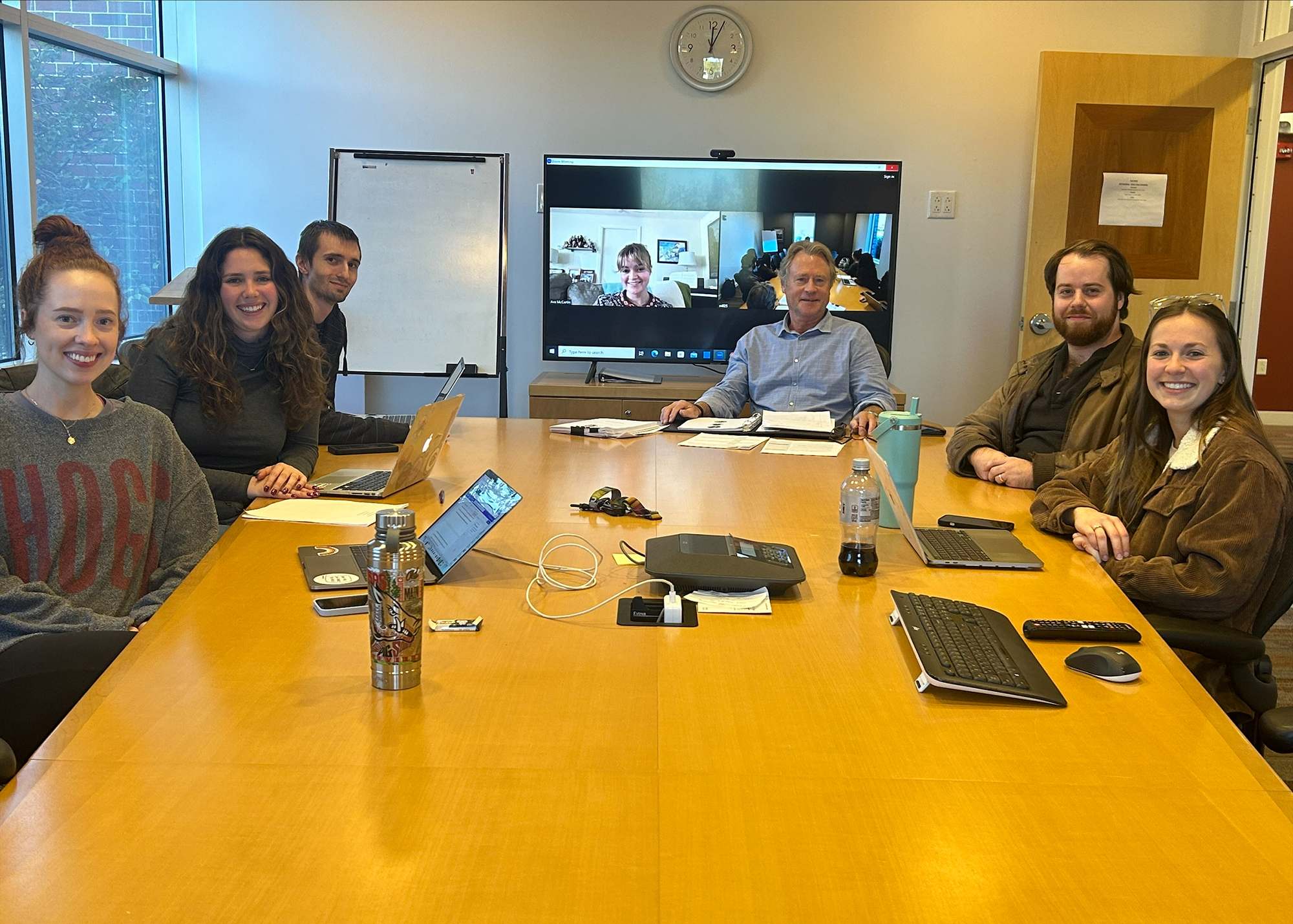 A group of people sit around a conference table for a meeting.