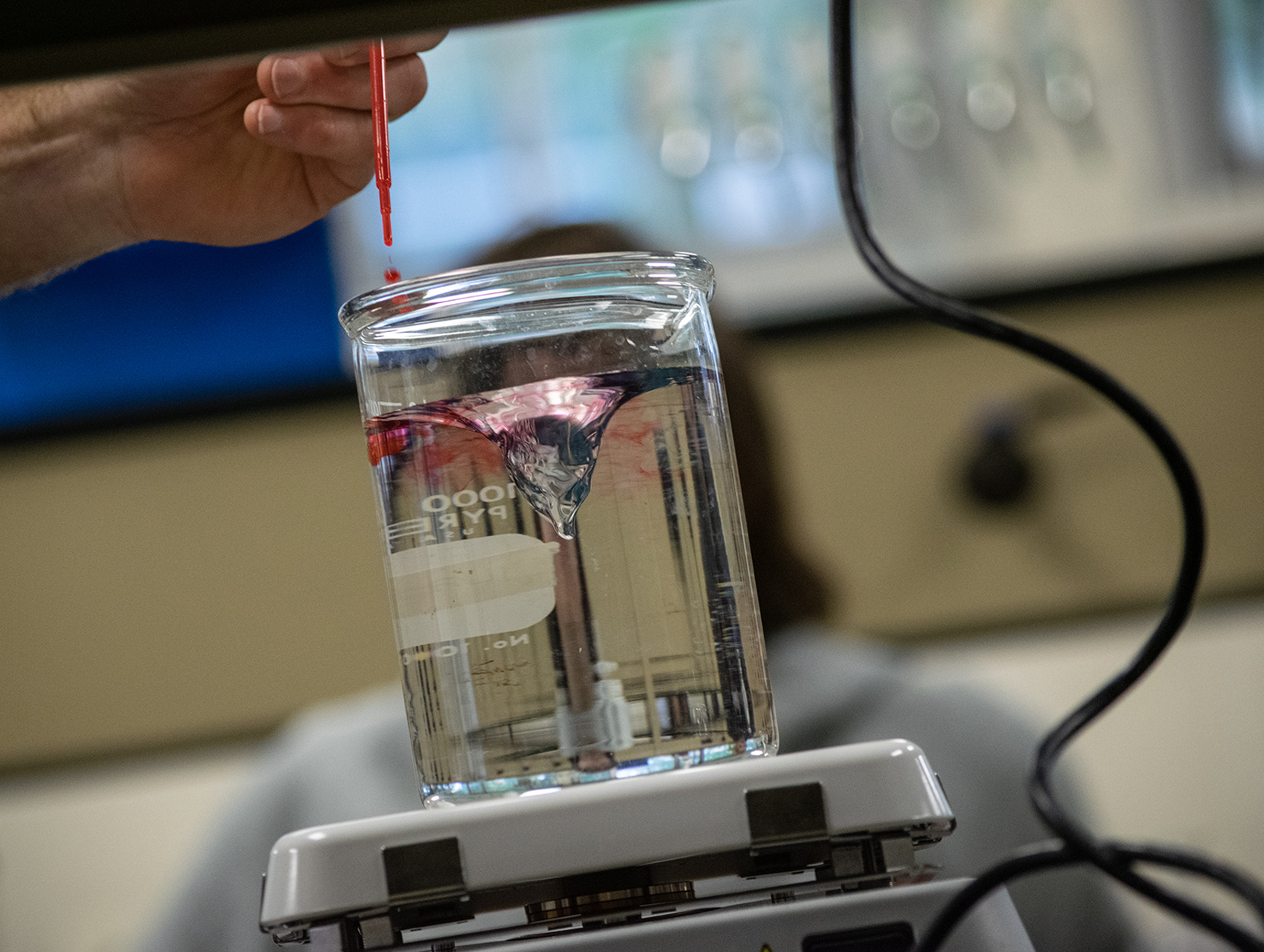 Red dye being added to a mixing beaker