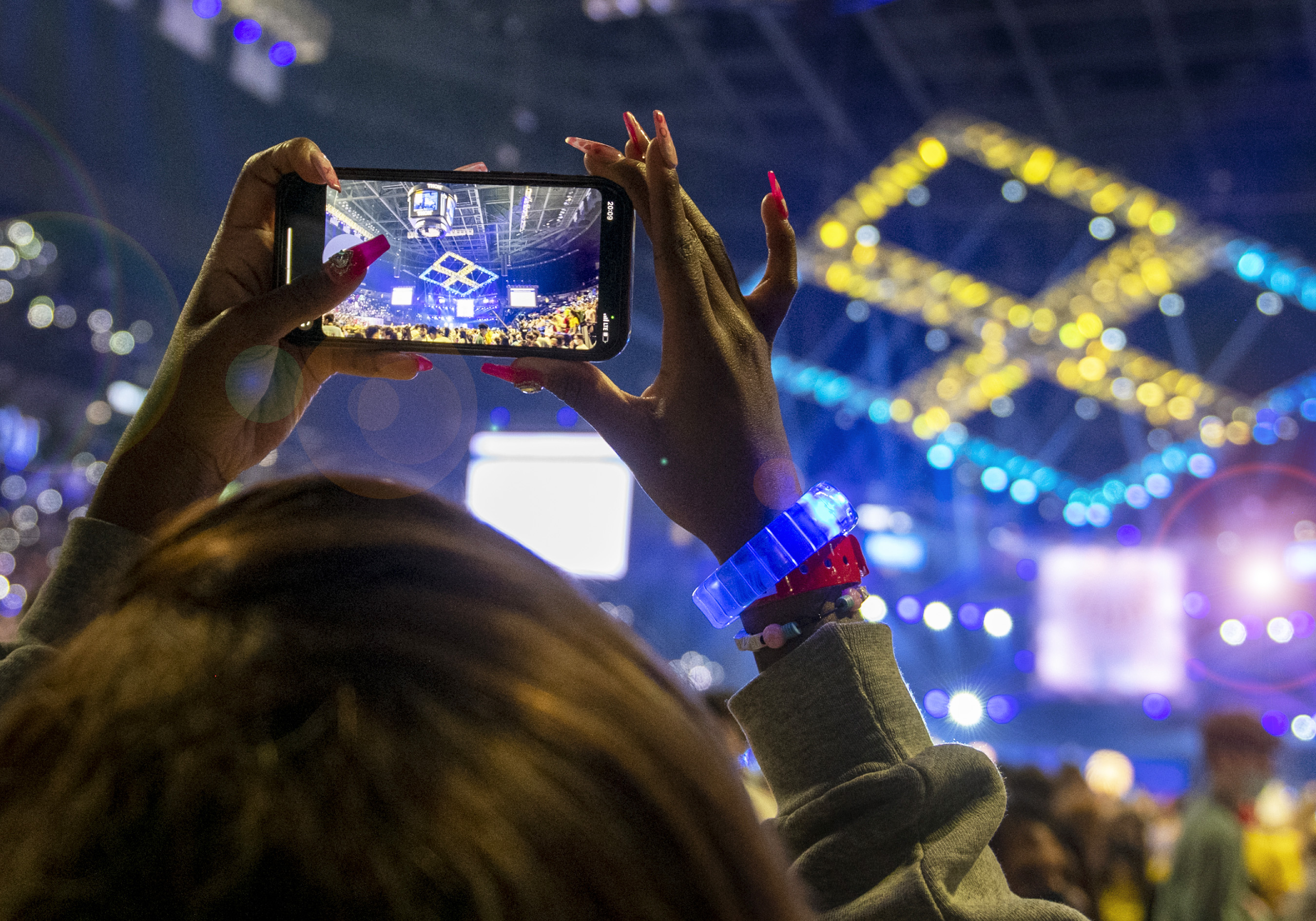 An individual at THON uses a smartphone to take a picture of the four diamonds on the ceiling