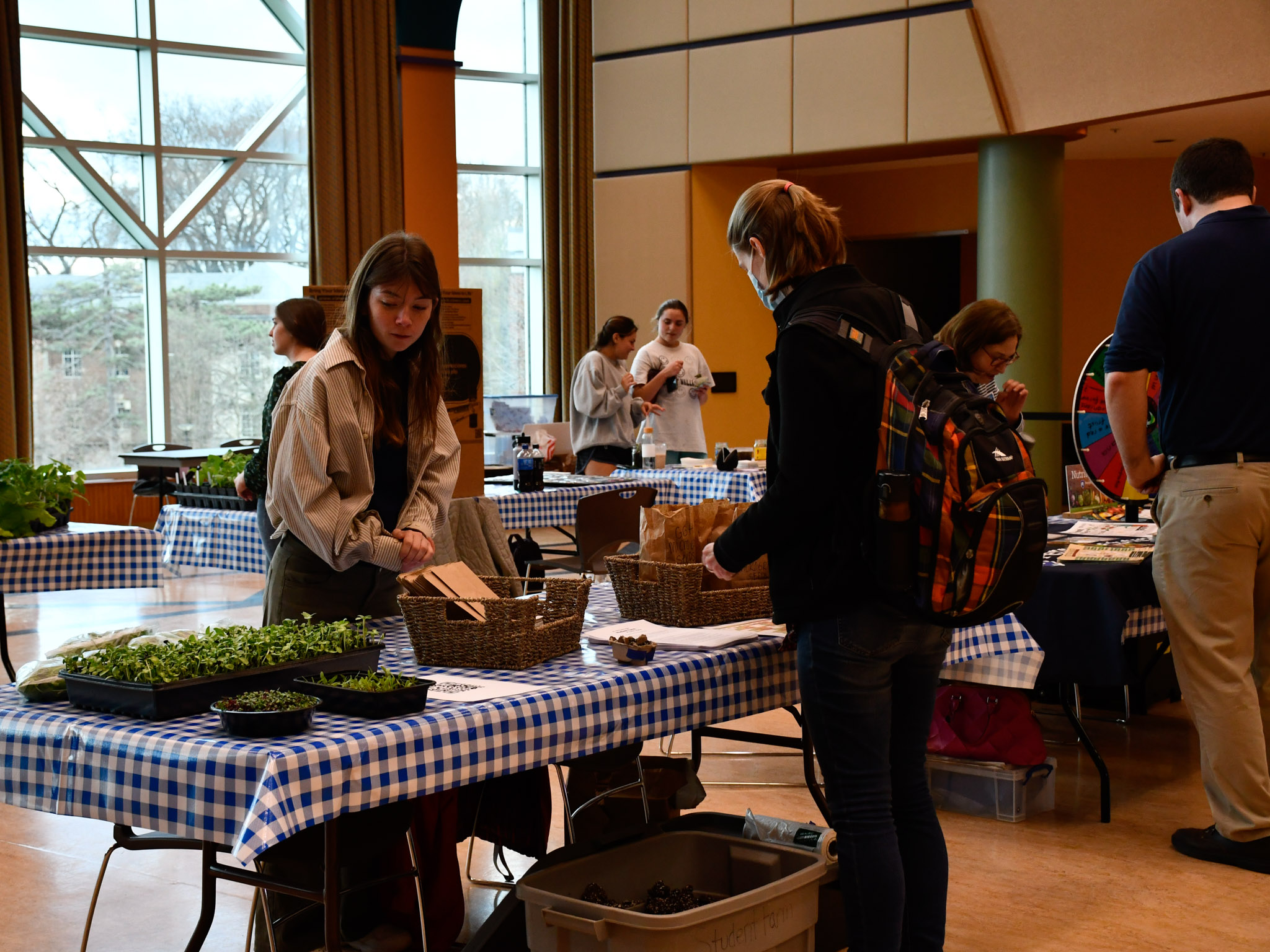 A visitor stops at a table to learn about planting seeds.