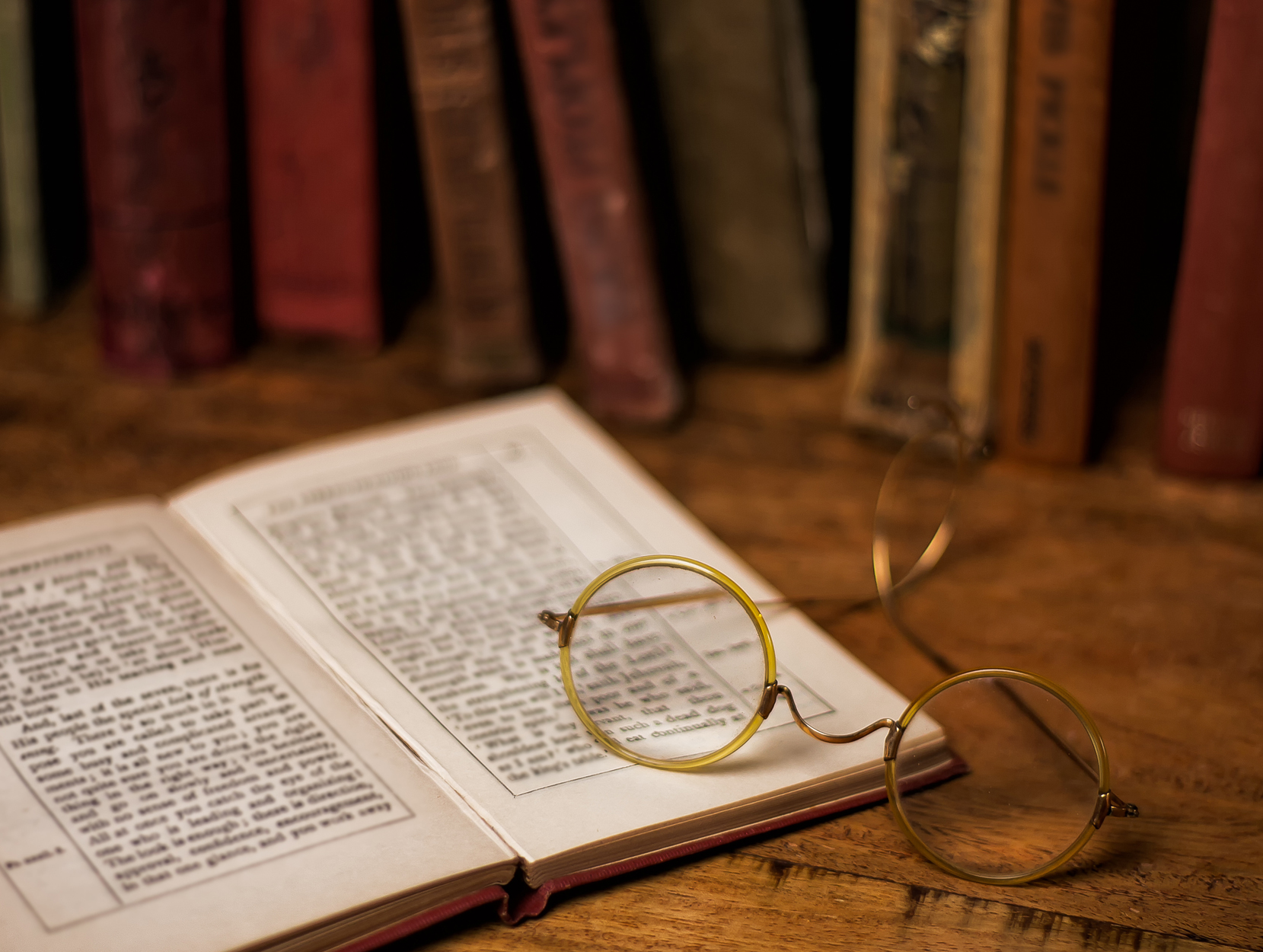 cirlcle frame eye glasses sitting atop an open book