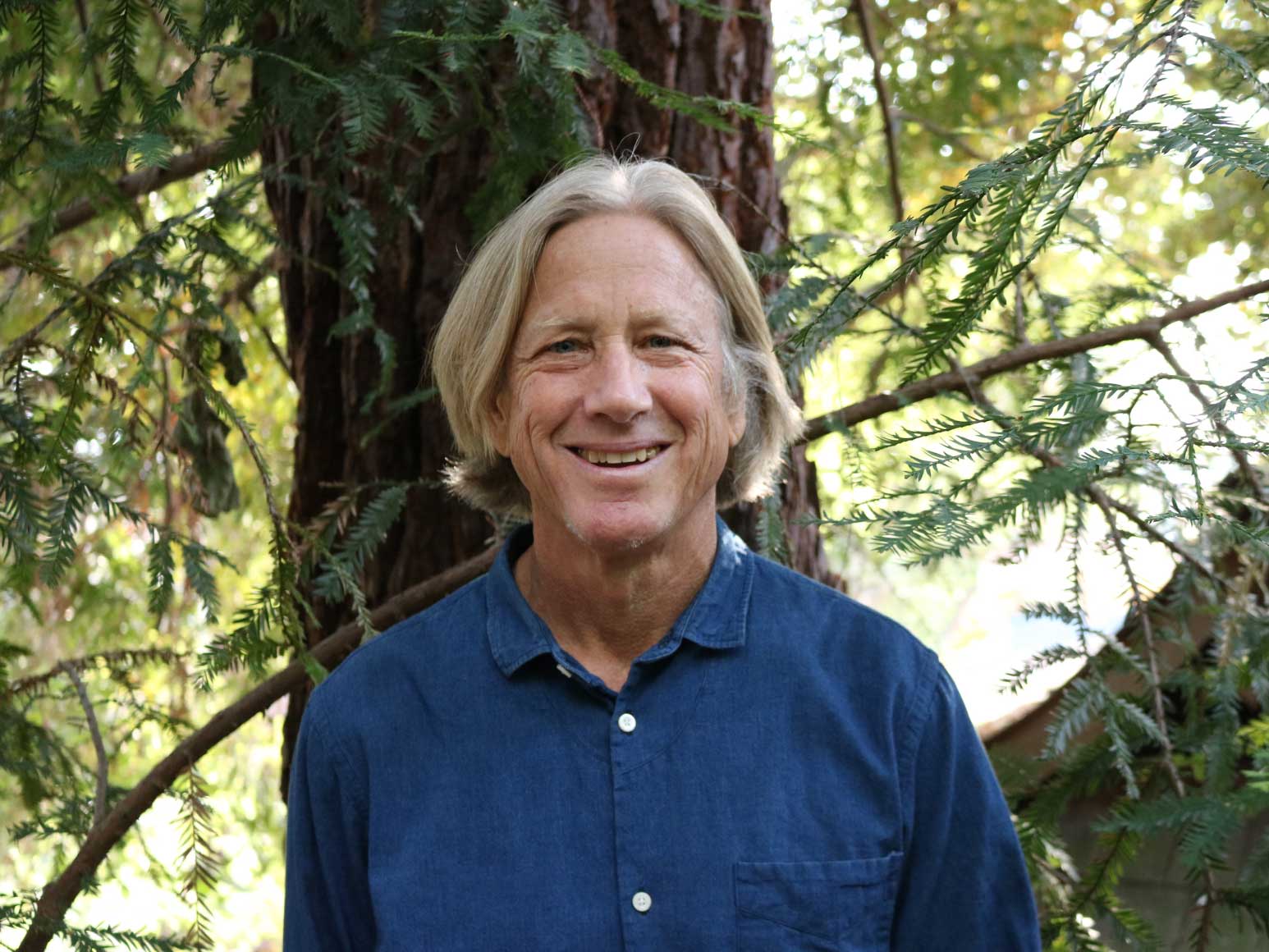 smiling man standing in the forest