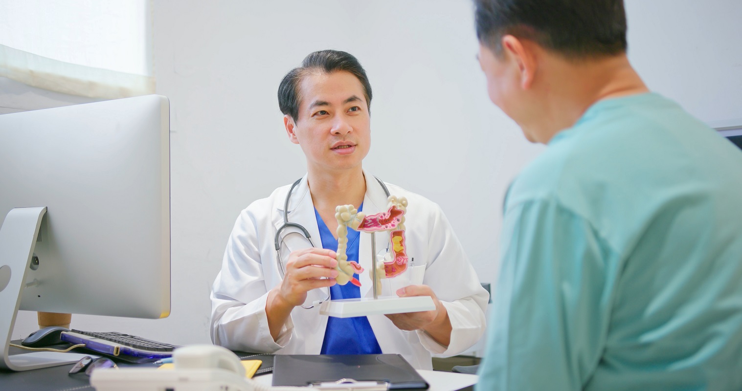 A doctor explains a colonoscopy result to a patient.