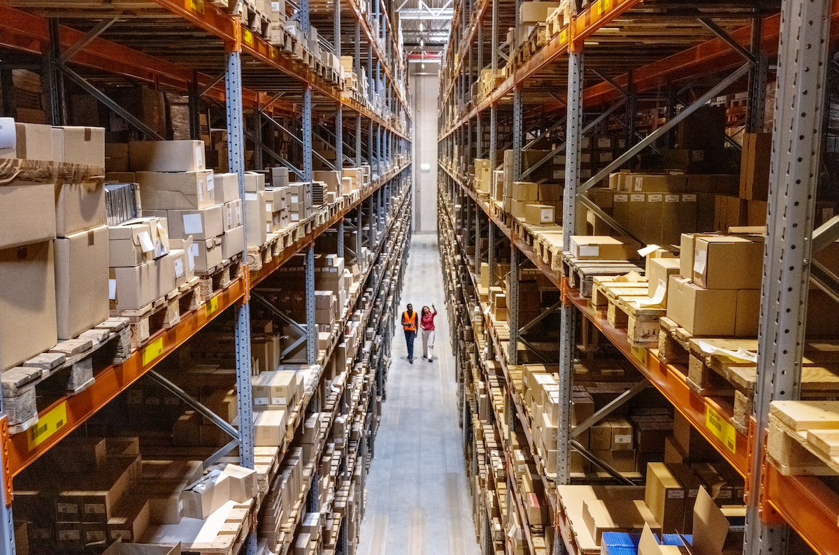 Two people walking through warehouse. 