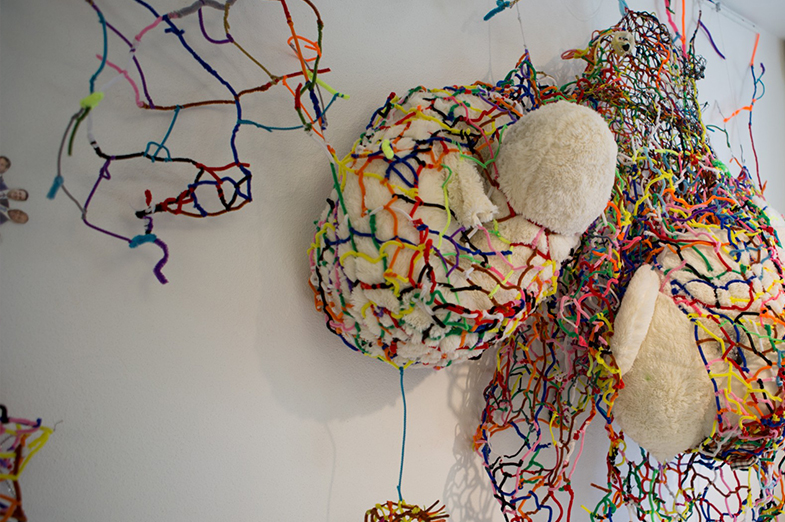 Abstract 3-D art installation with stuffed animal-like material wrapped in colorful thread