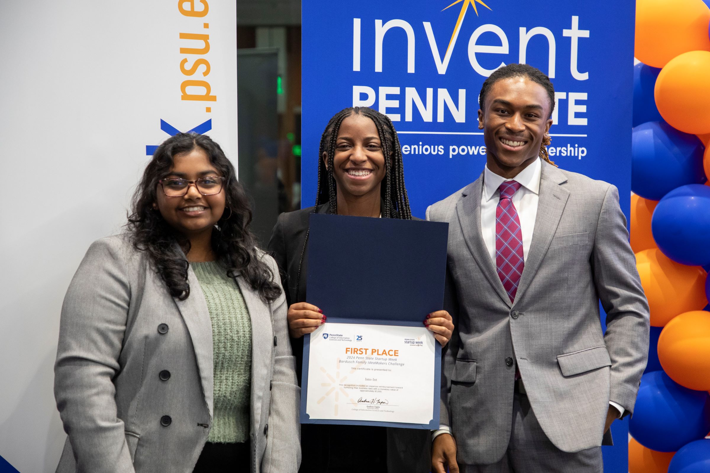 three smiling people display their first-place certificate