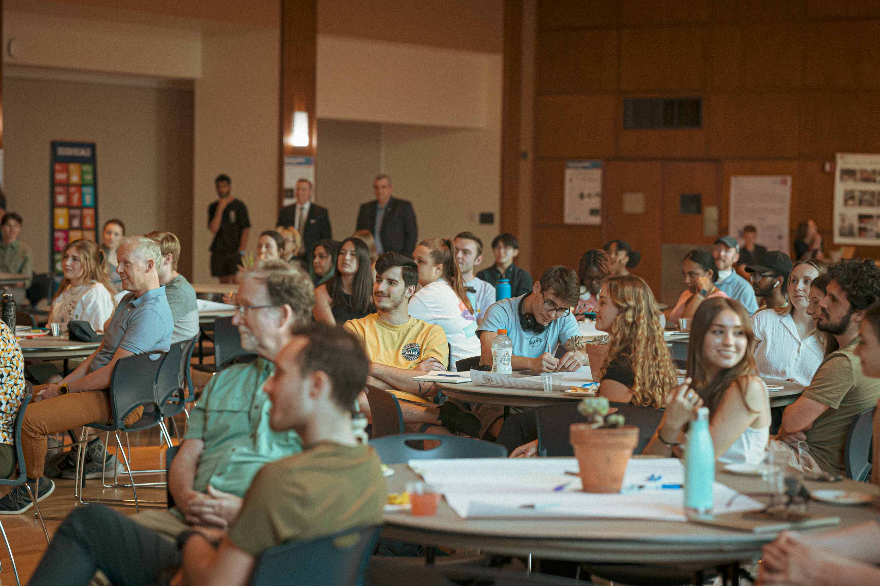 A group of people sitting in a room together listening to a speaker.