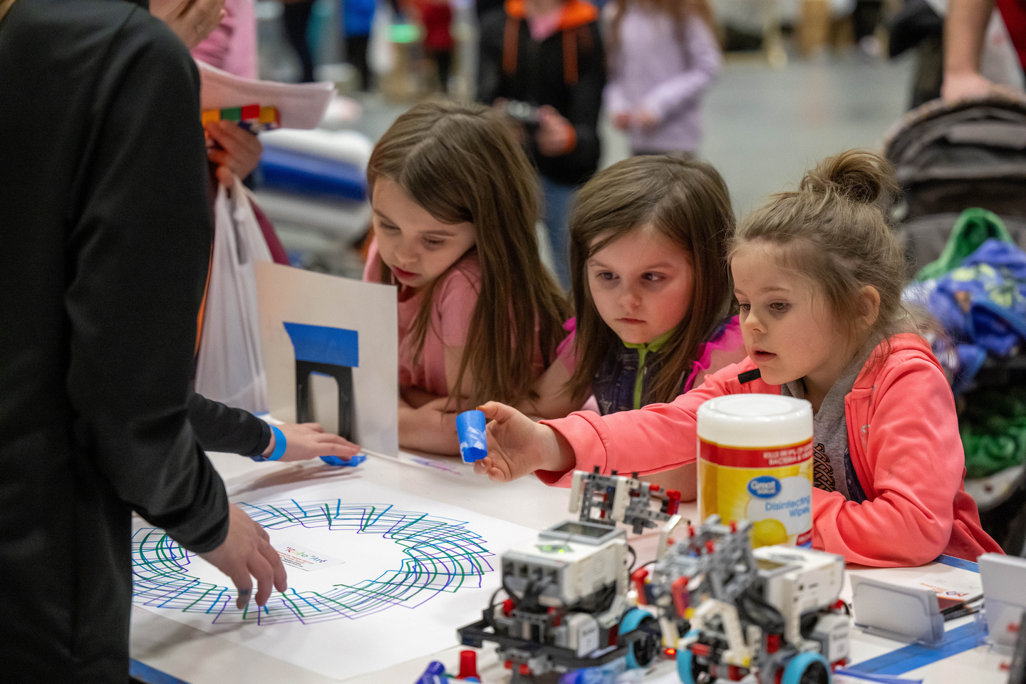 Three girls experiment with a robotic pen at Penn State Behrend's annual STEAM Fair.