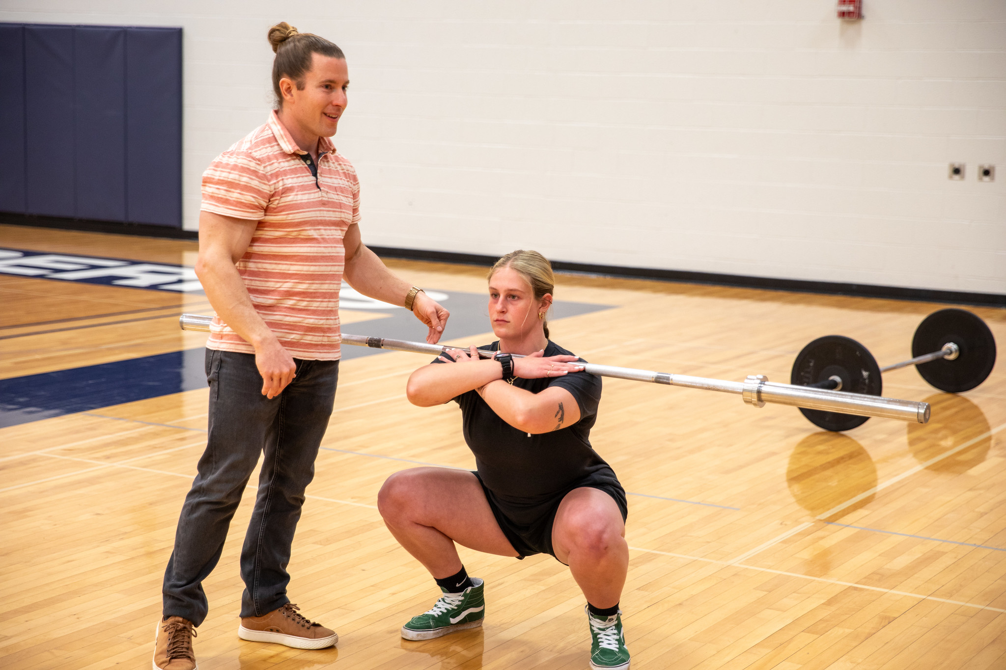 Student squats with lifting bar 