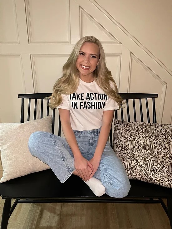 A woman sitting on an indoor bench.