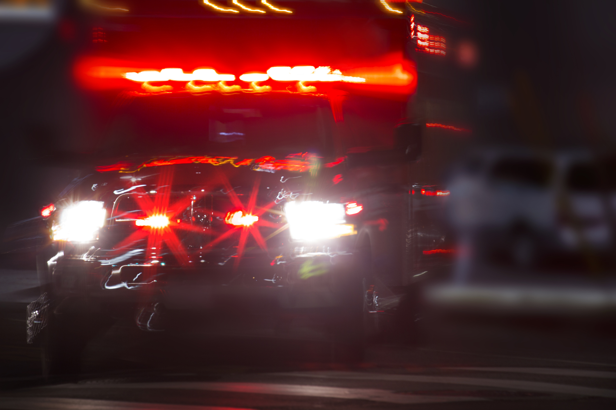 An ambulance racing through dark streets