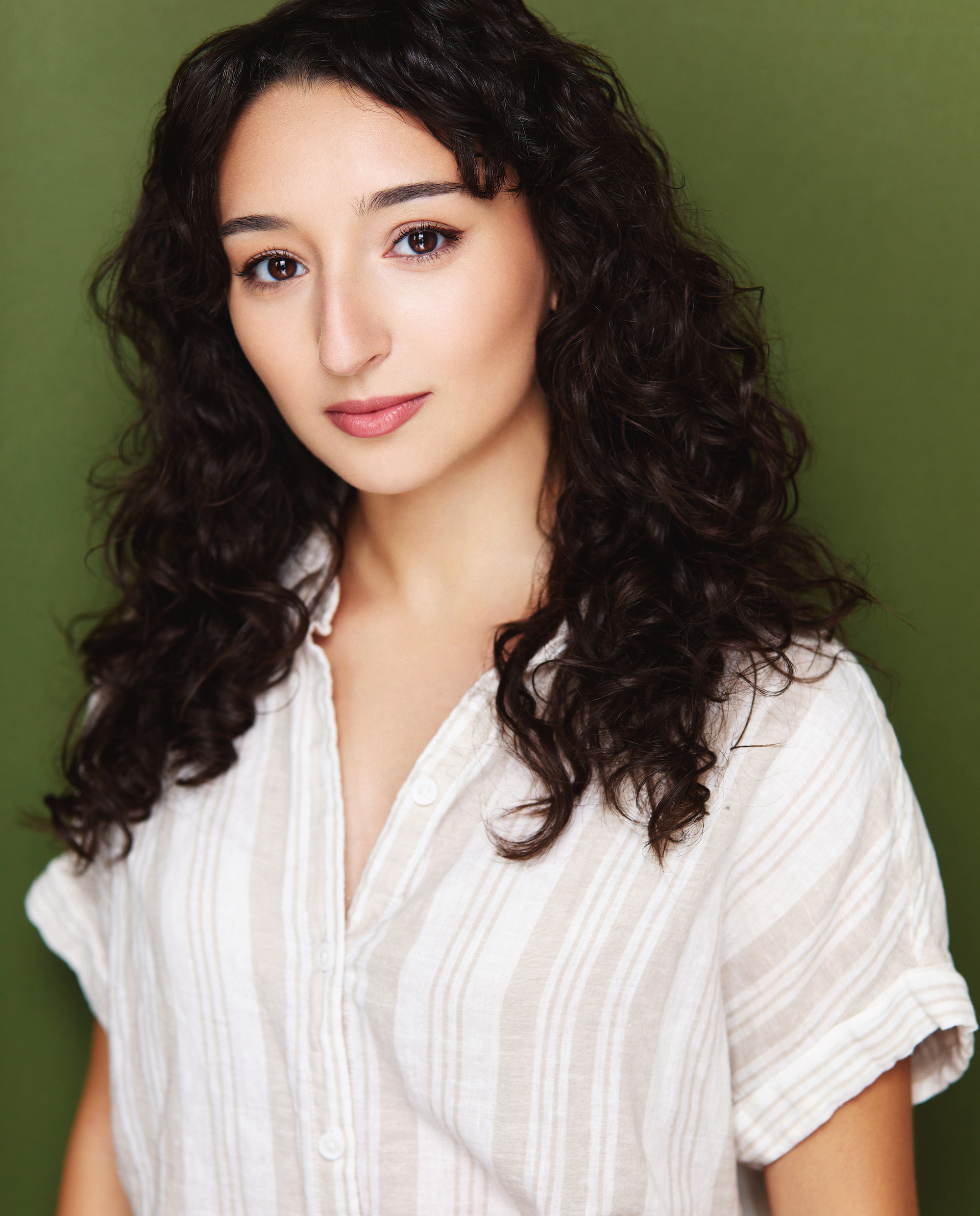 Head shot of a young woman with dark, wavy hair.